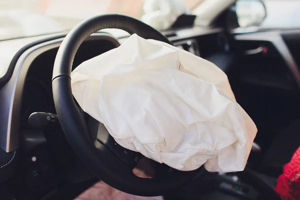 Interior de um automóvel ou automóvel envolvido num acidente de viação com um airbag de coluna de direcção implantado. — Fotografia de Stock