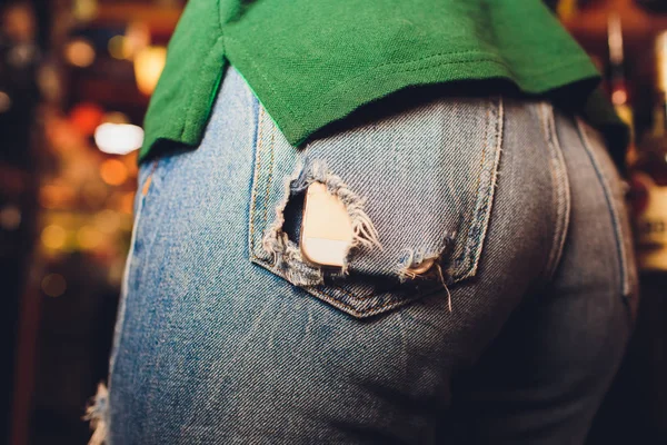 Smartphone with a black screen in the pocket of jeans hole. — Stock Photo, Image