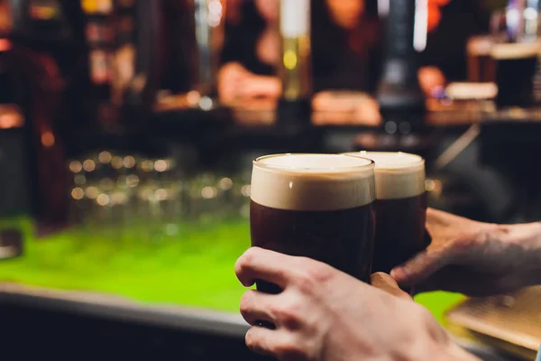 Le mani del barman versano una birra lager in un bicchiere. — Foto Stock