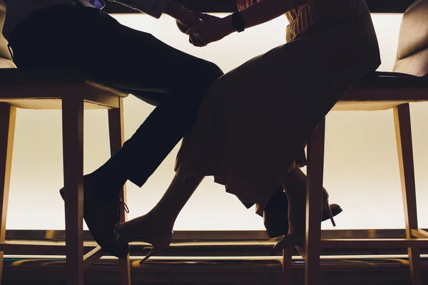 Paar Beine Silhouette verliebt Umarmung in einem Restaurant. — Stockfoto