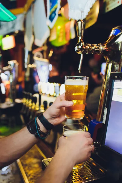 Barman verser de la bière fraîche du robinet dans le verre dans le pub. — Photo