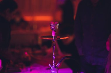 Nargile bulanık bir bar bir bokeh ile karanlık bir arka plan üzerinde. Kopya alanı.