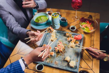Bir aile yemeği Sushi seti üzerinde Chopsticks tutarak. Düz yatıyordu, üst görünüm.