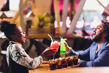 Genç insanlar bir kafede oturup konuşuyor. Cafe masasında genç adam ve kadın toplantısı.