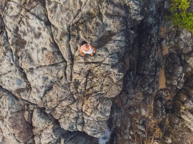 Maceracı adam dağın tepesinde ayakta ve canlı bir gün batımı sırasında güzel manzarayı zevk. Güzel