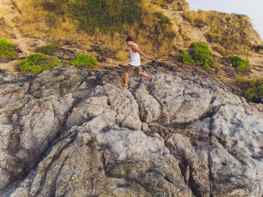 Maceracı adam dağın tepesinde ayakta ve canlı bir gün batımı sırasında güzel manzarayı zevk. Güzel
