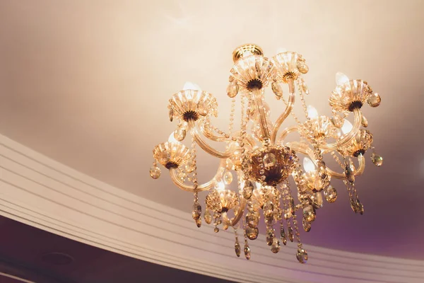 Chrystal chandelier lamp on the ceiling in Dining room Adjusting the image in a Luxury tone .Decorative elegant vintage and Contemporary interior Concept.