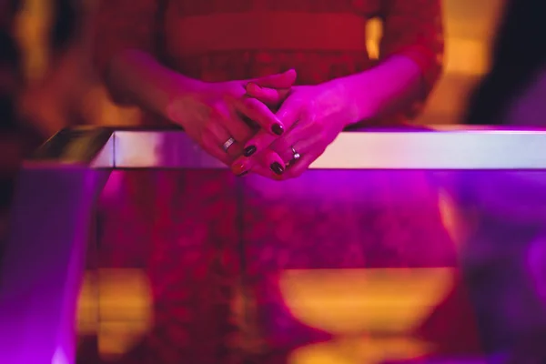 Κοντινό πλάνο σε γυναικεία χέρια διπλωμένα στην προσευχή σε ένα ξύλινο τραπέζι. — Φωτογραφία Αρχείου