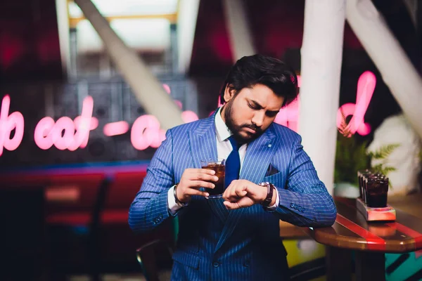 Joven guapo bebiendo cóctel en el mostrador del bar, usando traje de negocios . —  Fotos de Stock