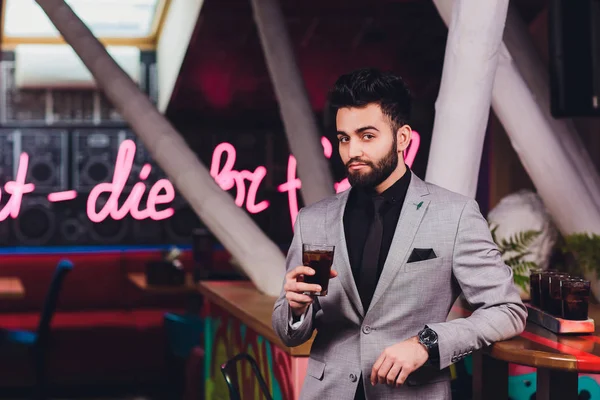 Knappe jonge man drinken cocktail bij bar Counter, het dragen van Business Suit. — Stockfoto