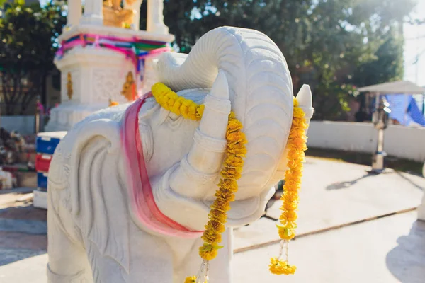 White elephant sculptures with yellow marigold flowers.