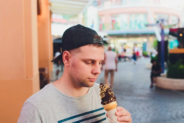Short bearded man eating ice cream cone in a town street. — Stock Photo, Image