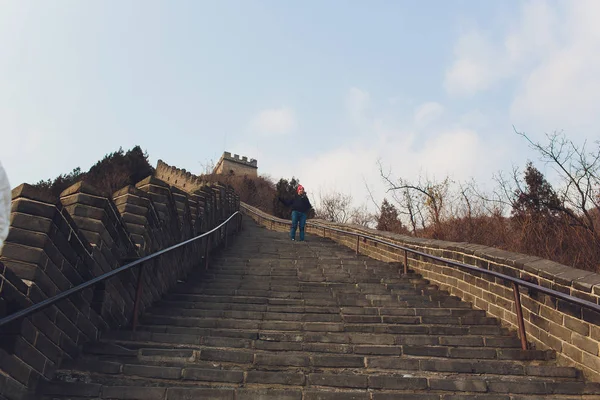 Młody zagraniczny turysta jest wspinaczka Wielkiego Muru chińskiego w pięknym dniu. — Zdjęcie stockowe