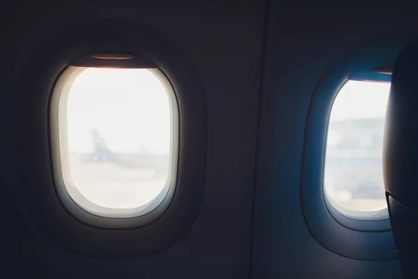Asiento y ventana del avión dentro de una aeronave con vista a las nubes . — Foto de Stock