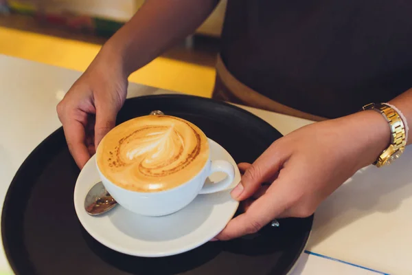 Mãos femininas segurando Latte arte, xícara de café . — Fotografia de Stock