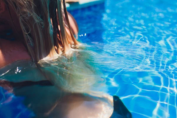 Mooie vrouw verhogen haar hoofd uit het water in een zwembad. — Stockfoto