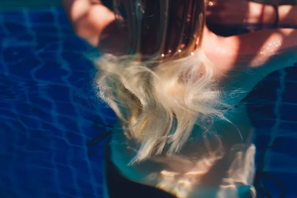 Mooie vrouw verhogen haar hoofd uit het water in een zwembad. — Stockfoto