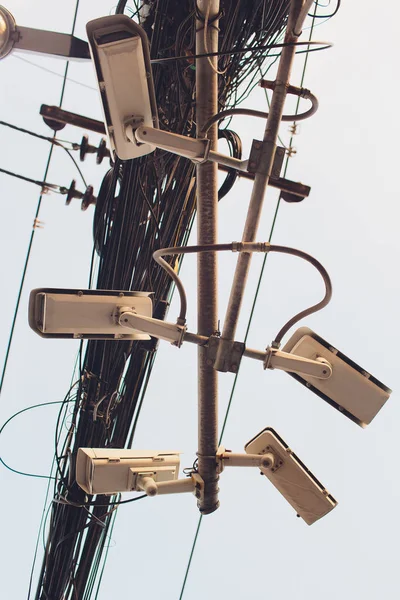 Bezpieczeństwo Kamera CCTV jest instalowany w trzech kierunkach w post z wieloma kablami. Bałaganu przewodów. Rozwój niesystematyczny. System antykradzieżowy. Nadzór. zdezorganizowana. elektryczność. — Zdjęcie stockowe