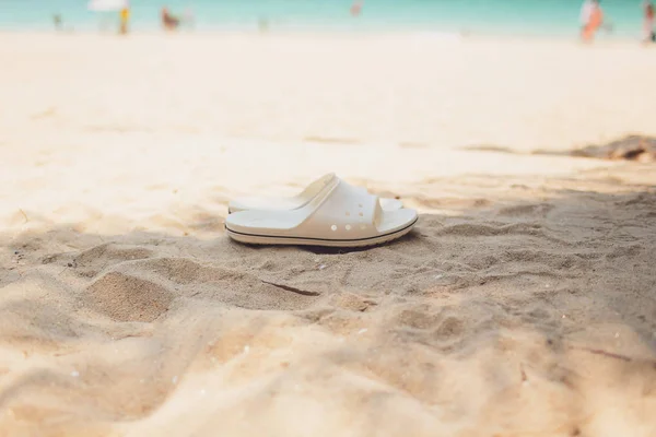 Conceito de férias de verão. Chinelos em uma praia de areia oceânica . — Fotografia de Stock