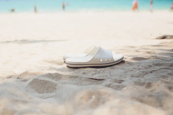 Conceito de férias de verão. Chinelos em uma praia de areia oceânica . — Fotografia de Stock