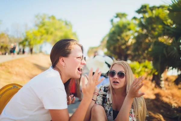 Parler amicalement. Deux belles jeunes femmes marchant le long de la rue et parlant . — Photo