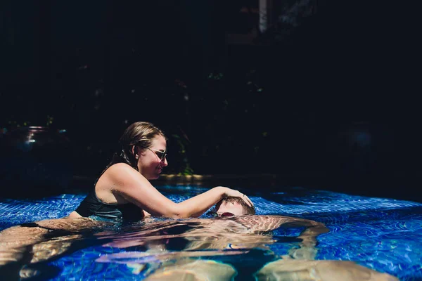 Vrouw verdrinkt een man in het zwembad. — Stockfoto
