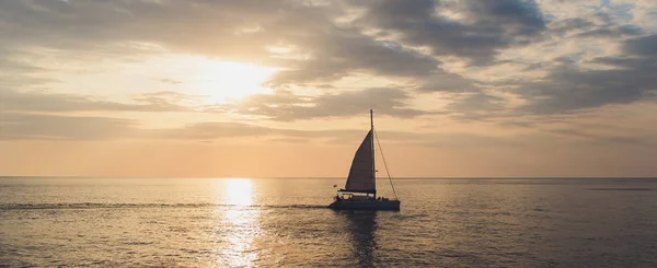 Jacht segelt gegen Sonnenuntergang. Urlaubslandschaft mit Skyline-Segelboot und zwei Möwen. Yachttourismus - maritimer Abendspaziergang. Romantischer Ausflug auf einer Luxusjacht während des Sonnenuntergangs am Meer. — Stockfoto