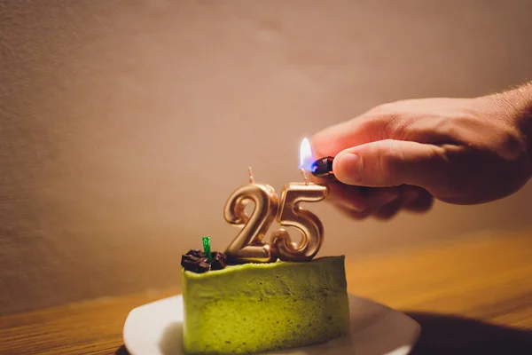 Vinte e cinco anos. Bolo de chocolate de aniversário com velas brancas em forma de número 25. Fundo escuro com pano preto . — Fotografia de Stock