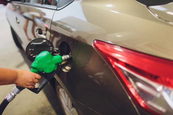 Man Fulling tank met brandstof op bokeh achtergrond. — Stockfoto