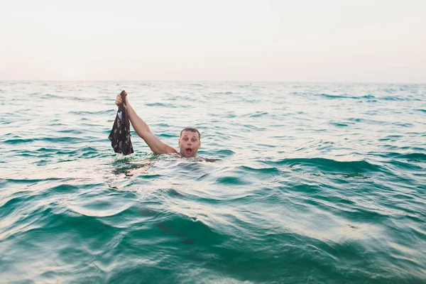 Man nam zwembroeken, terwijl in het water, de zee. — Stockfoto