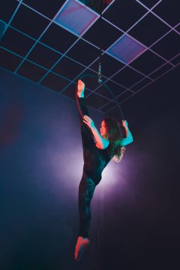 Hava acrobat içinde belgili tanımlık çalmak. Genç bir kız akrobatik öğeleri hava ringde gerçekleştirir..