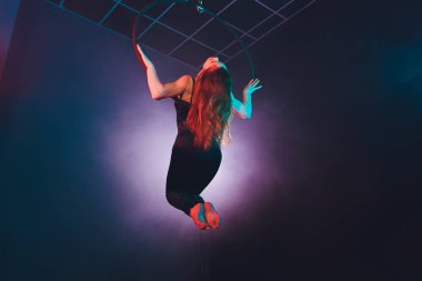 Hava acrobat içinde belgili tanımlık çalmak. Genç bir kız akrobatik öğeleri hava ringde gerçekleştirir..