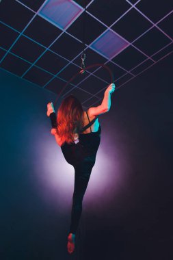 Hava acrobat içinde belgili tanımlık çalmak. Genç bir kız akrobatik öğeleri hava ringde gerçekleştirir..