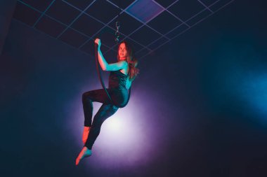 Hava acrobat içinde belgili tanımlık çalmak. Genç bir kız akrobatik öğeleri hava ringde gerçekleştirir..