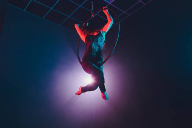 Hava acrobat içinde belgili tanımlık çalmak. Genç bir kız akrobatik öğeleri hava ringde gerçekleştirir..