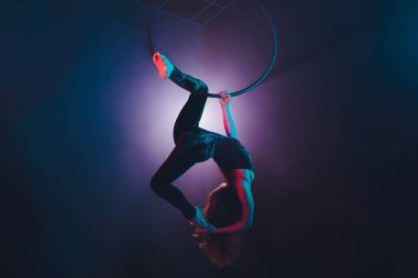 Hava acrobat içinde belgili tanımlık çalmak. Genç bir kız akrobatik öğeleri hava ringde gerçekleştirir..