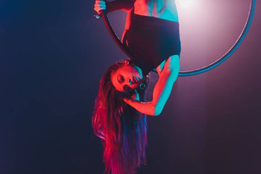 Hava acrobat içinde belgili tanımlık çalmak. Genç bir kız akrobatik öğeleri hava ringde gerçekleştirir..