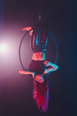 Hava acrobat içinde belgili tanımlık çalmak. Genç bir kız akrobatik öğeleri hava ringde gerçekleştirir..