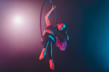 Hava acrobat içinde belgili tanımlık çalmak. Genç bir kız akrobatik öğeleri hava ringde gerçekleştirir..