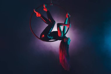 Hava acrobat içinde belgili tanımlık çalmak. Genç bir kız akrobatik öğeleri hava ringde gerçekleştirir..