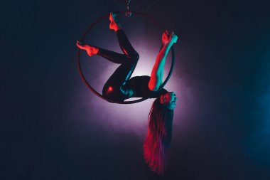 Hava acrobat içinde belgili tanımlık çalmak. Genç bir kız akrobatik öğeleri hava ringde gerçekleştirir..