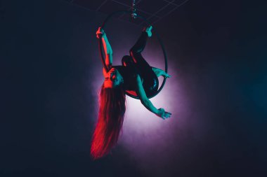 Hava acrobat içinde belgili tanımlık çalmak. Genç bir kız akrobatik öğeleri hava ringde gerçekleştirir..