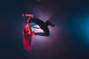 Hava acrobat içinde belgili tanımlık çalmak. Genç bir kız akrobatik öğeleri hava ringde gerçekleştirir..