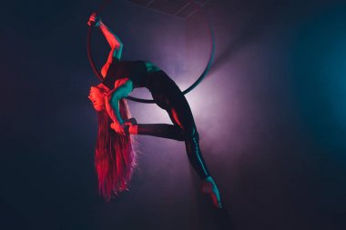 Hava acrobat içinde belgili tanımlık çalmak. Genç bir kız akrobatik öğeleri hava ringde gerçekleştirir..