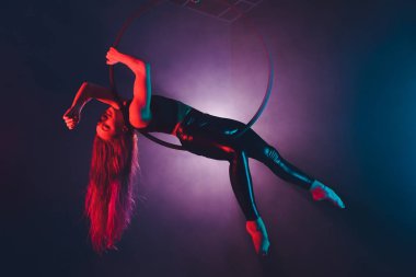 Hava acrobat içinde belgili tanımlık çalmak. Genç bir kız akrobatik öğeleri hava ringde gerçekleştirir..