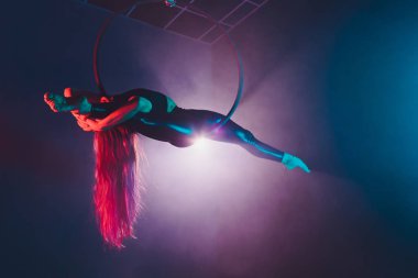 Hava acrobat içinde belgili tanımlık çalmak. Genç bir kız akrobatik öğeleri hava ringde gerçekleştirir..