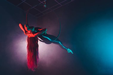 Hava acrobat içinde belgili tanımlık çalmak. Genç bir kız akrobatik öğeleri hava ringde gerçekleştirir..