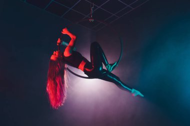 Hava acrobat içinde belgili tanımlık çalmak. Genç bir kız akrobatik öğeleri hava ringde gerçekleştirir..