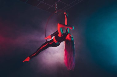 Hava acrobat içinde belgili tanımlık çalmak. Genç bir kız akrobatik öğeleri hava ringde gerçekleştirir..