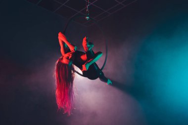 Hava acrobat içinde belgili tanımlık çalmak. Genç bir kız akrobatik öğeleri hava ringde gerçekleştirir..